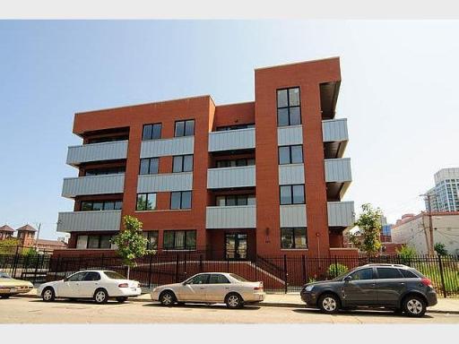 Front view of a multi-story building with a modern design and balconies.
