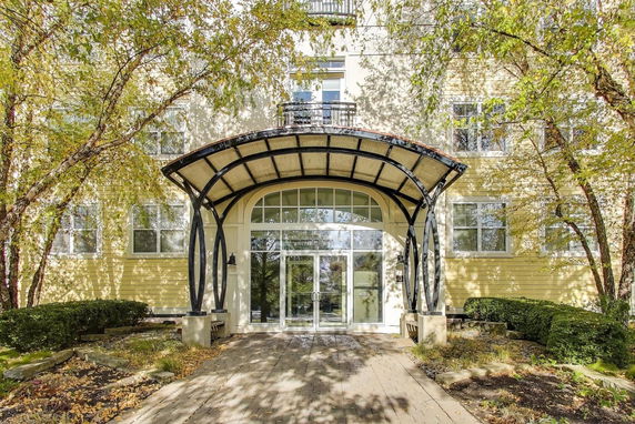 Front view of a multi-story building with a glass entrance and decorative metal awning.