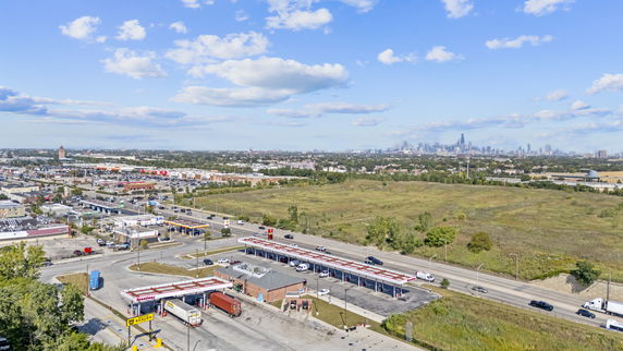Panoramic view of a cityscape with roads, buildings, and distant skyscrapers.