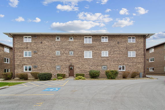Front view of a three-story brick building with multiple windows and a central entrance.