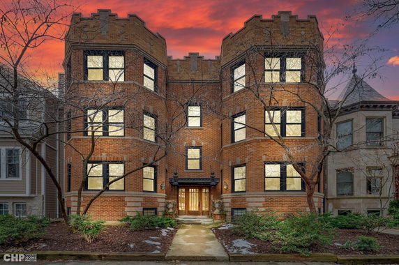 Front view of a brick apartment building with multiple windows and a central entrance.