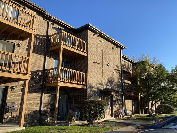 Front view of a multi-story brick building with wooden balconies.