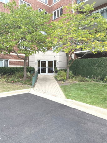Front view of a multi-story brick building with a pathway leading to the entrance.