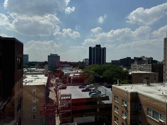 Panoramic view of urban landscape with multiple buildings and parking areas.