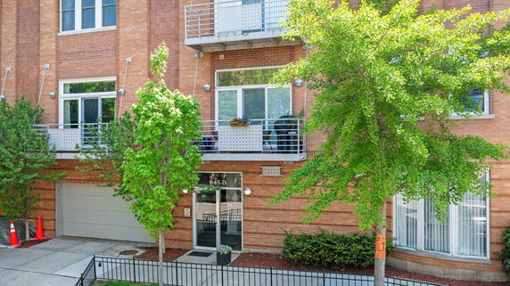 Front view of a residential building with balconies and a garage.