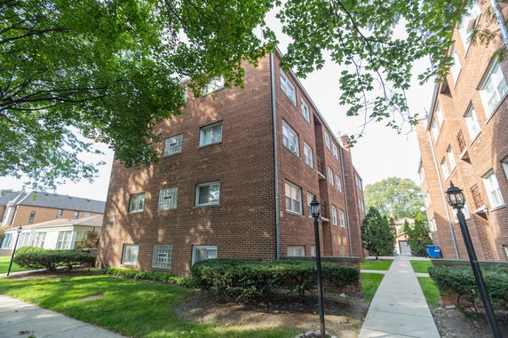 Front view of a multi-story brick apartment building.