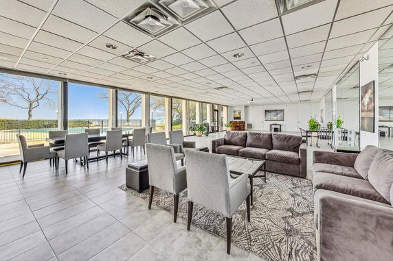 Spacious indoor clubhouse area with seating arrangements and large windows.