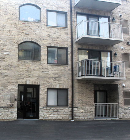 Front view of a brick residential building with balconies.