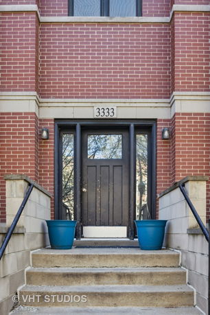 Entrance to a brick building with blue planters and brick walls.
