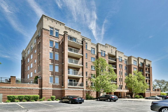 Front view of a multi-story brick apartment building with balconies.