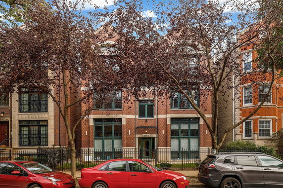 Front view of a multi-story brick building with large windows.