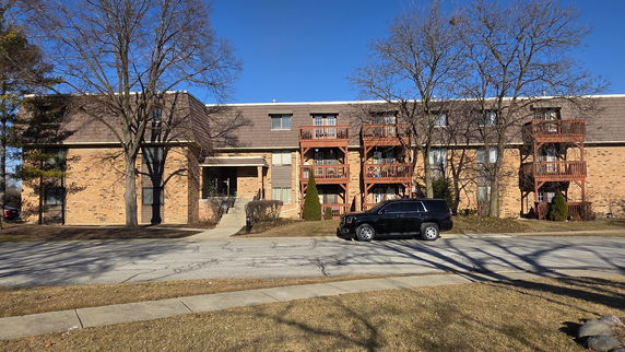 Front view of a multi-story apartment building with balconies.