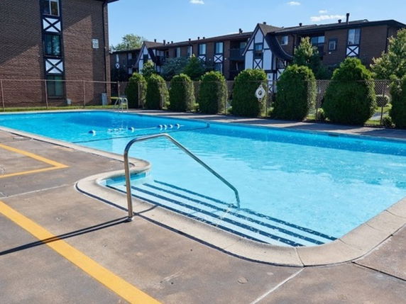 Outdoor swimming pool surrounded by apartment buildings.
