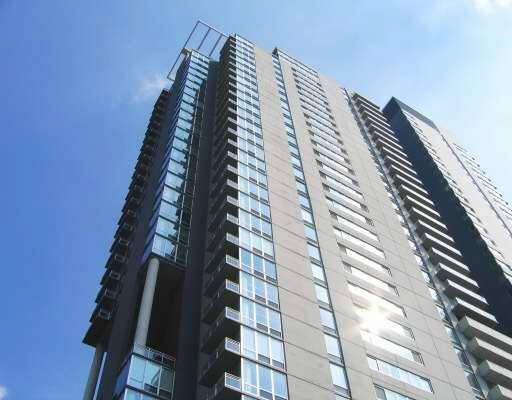 Front view of a modern high-rise building with multiple floors and glass balconies.