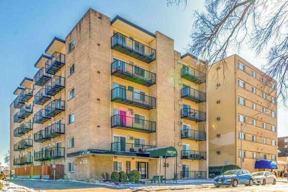 Front view of a multi-story apartment building with balconies.
