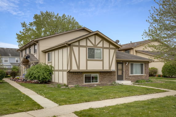 Front view of a two-story house with brick and wood paneling.