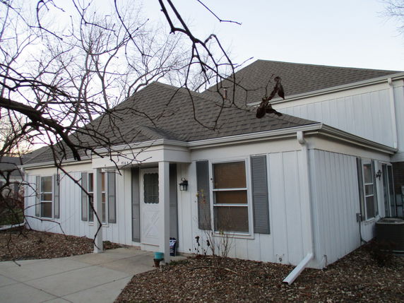 Front view of a single-story house with a gabled roof and white siding.