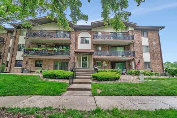 Front view of a multi-story apartment building with balconies.
