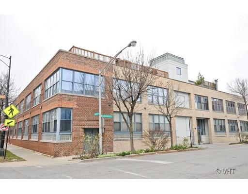 Front view of a multi-story brick building with large windows.
