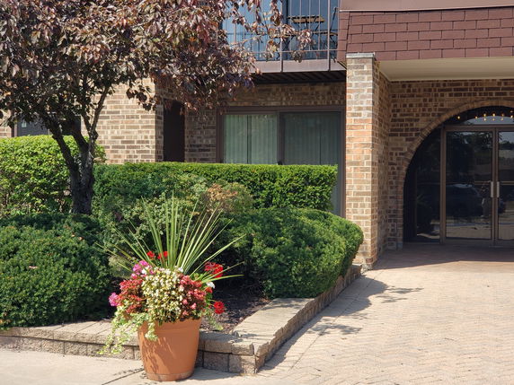 Front view of a building with brick facade and arched entryway.