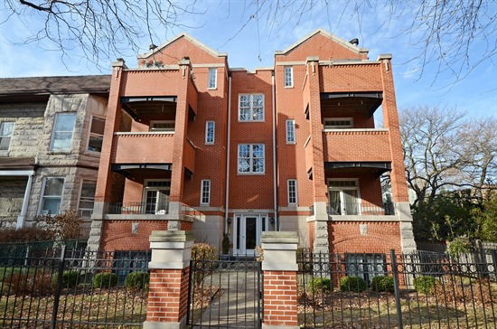 Front view of a multi-story brick building with multiple balconies.
