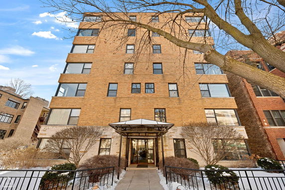 Front view of a multi-story brick building with a covered entrance.