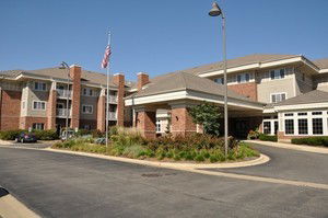Front view of a multi-story building with a driveway and flagpole.
