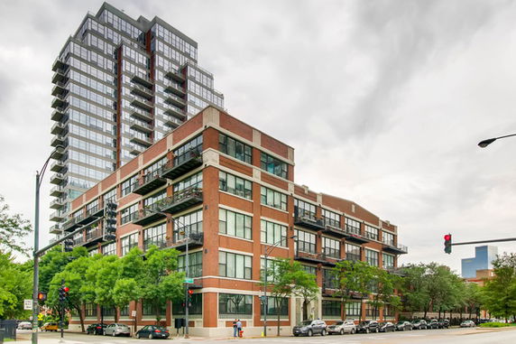 Front view of a modern multi-story building with brick and glass facade.