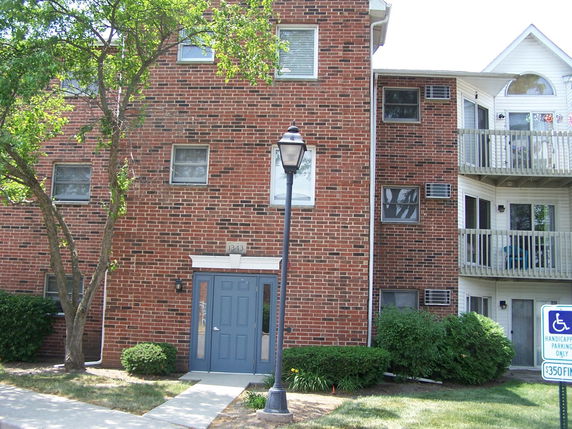 Front view of a multi-story brick apartment building.