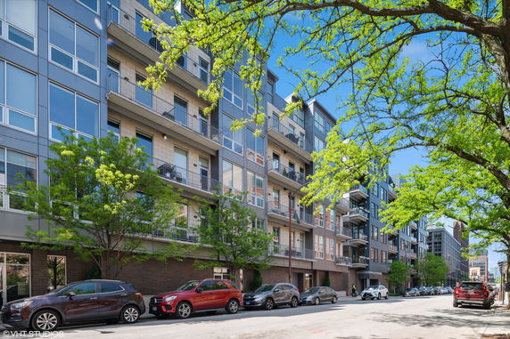 Front view of a multi-story residential building with balconies and large windows.