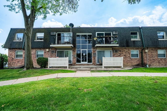 Front view of a two-story brick apartment building with balconies.