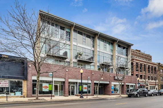 Front view of a multi-story commercial building with large windows.