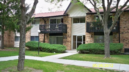 Front view of a two-story building with balconies and a central entrance.