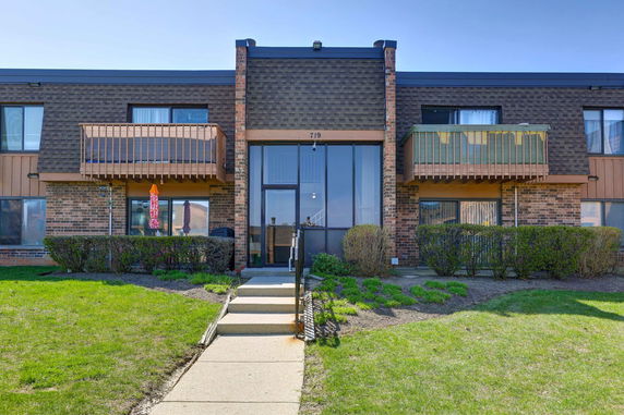 Front view of a two-story brick building with balconies and a central entrance.