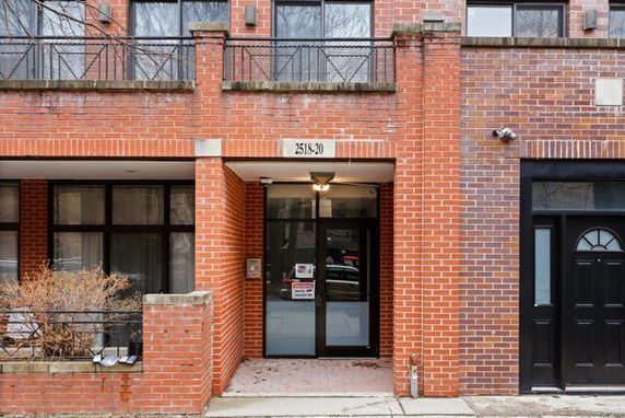 Front view of a brick building entrance with a covered doorway.