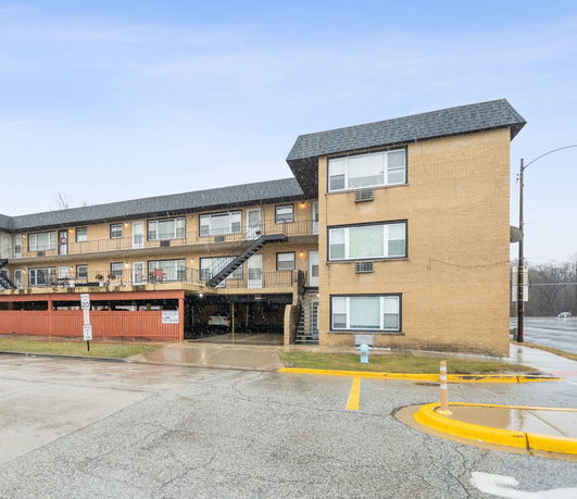 Front view of a multi-story apartment building with external staircases.