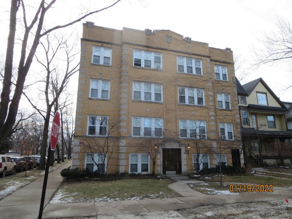 Front view of a four-story apartment building with a brick facade.