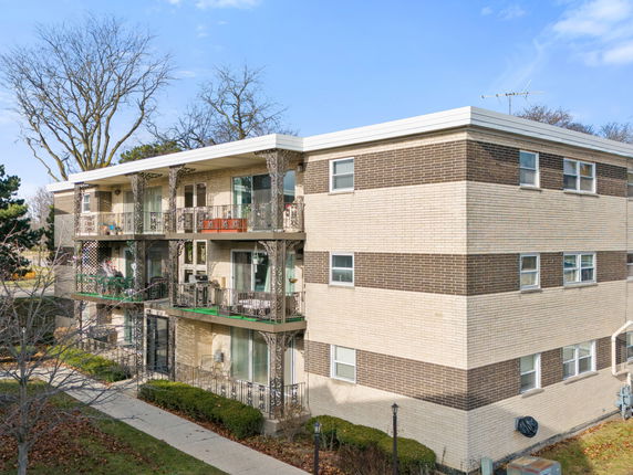 Front view of a multi-story apartment building with balconies.