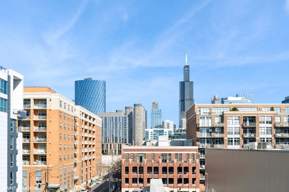 View of surrounding buildings in an urban area with a clear blue sky.