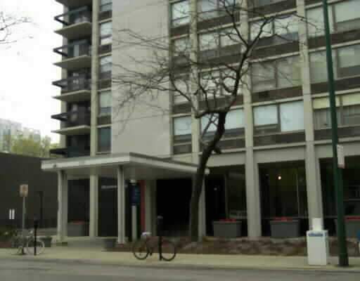 Front view of a multi-story building with a main entrance and balconies.