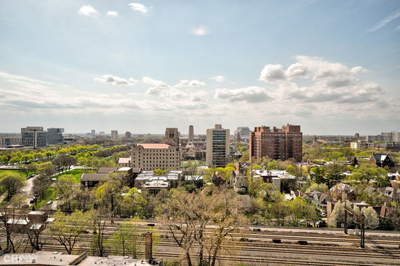 Panoramic view of a cityscape with various buildings and greenery.