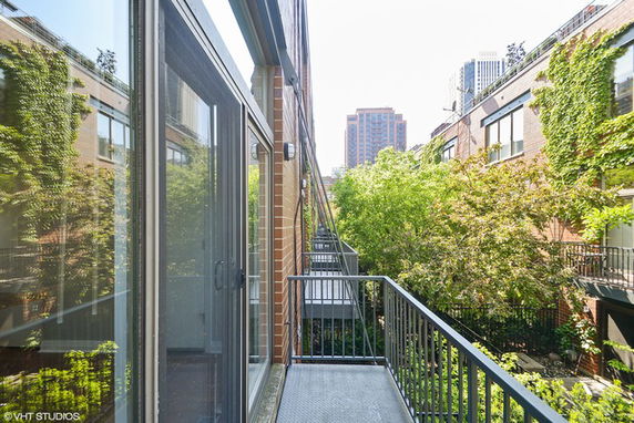 View from a balcony overlooking city buildings and greenery.