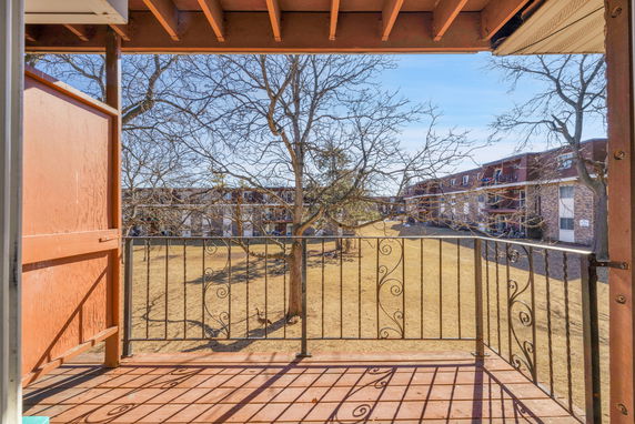 Panoramic view from a balcony overlooking a courtyard and apartment buildings.
