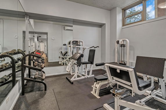 Indoor gym area with exercise equipment and mirrors.