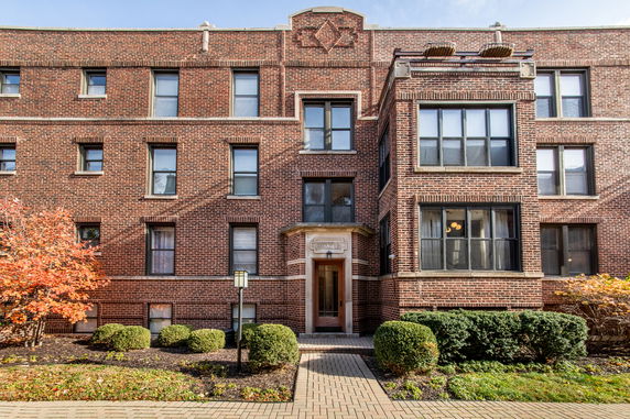 Front view of a multi-story brick building with symmetrical window placement.
