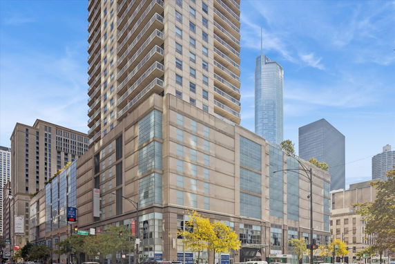 Front view of a tall multi-story building with balconies and large windows.