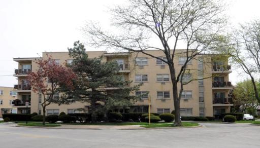 Front view of a four-story apartment building with balconies.