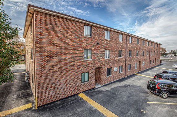 Side view of a three-story brick building with multiple windows.