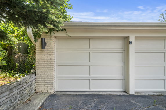 Front view of a house with a garage door and brick exterior.