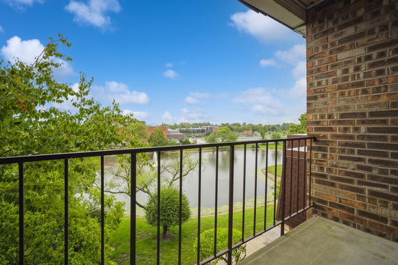 View from a balcony showing a lake and distant buildings.